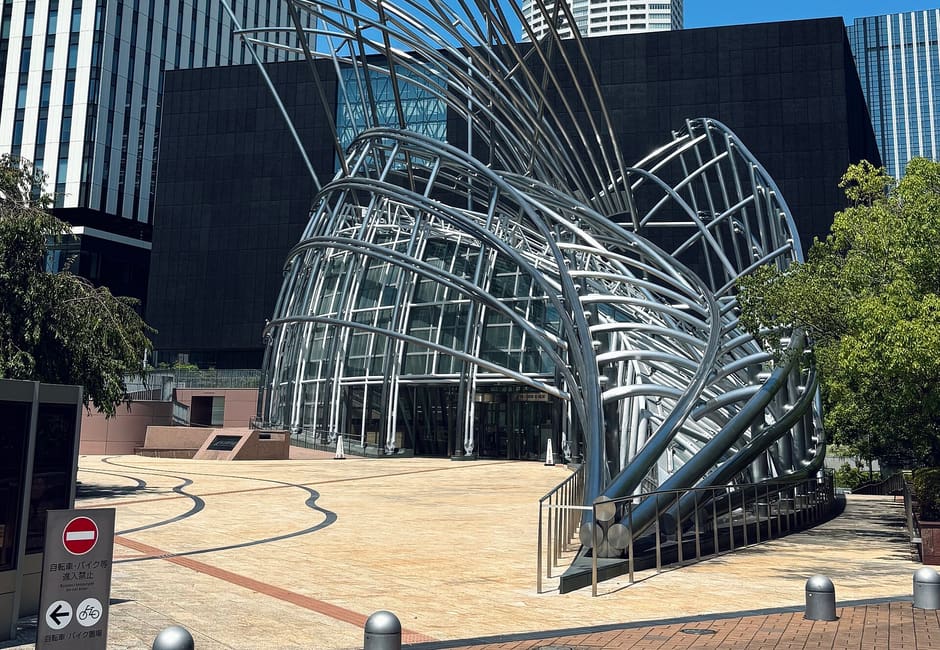 Steel-framed sculptural entrance of the National Museum of Art, Osaka against a clear blue sky